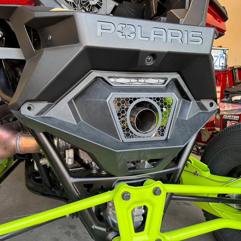 
                  
                    Rear view of a Polaris RZR Pro R featuring a custom turbo exhaust tip integrated into the factory rear fascia with a honeycomb mesh trim.
                  
                