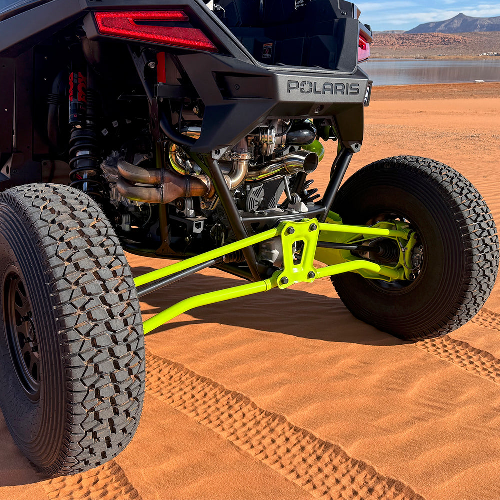 
                  
                    Rear view of a Polaris RZR Pro R equipped with the H&S Motorsports Easy Boost Turbo Kit, showcasing the upgraded exhaust and suspension components on red sand terrain.
                  
                