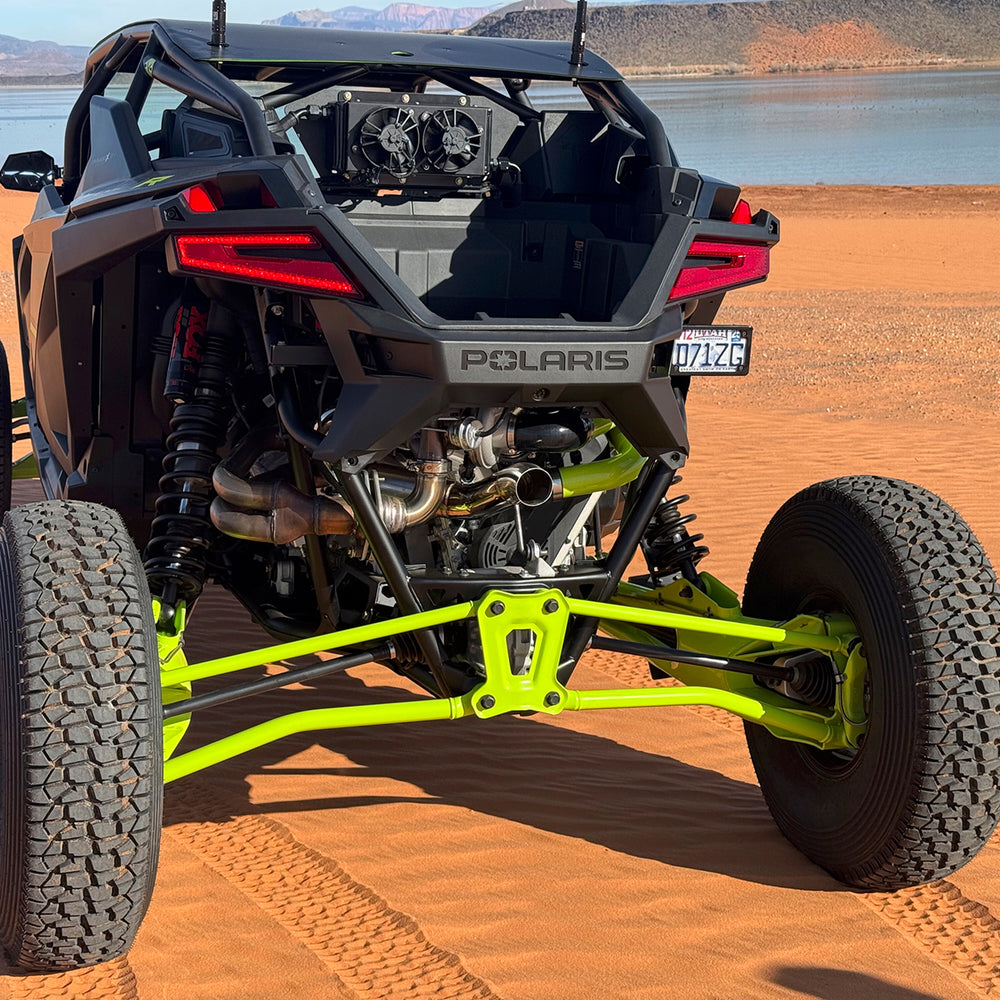 
                  
                    Rear view of a Polaris RZR Pro R parked on red sand, equipped with the H&S Motorsports Easy Boost Turbo Kit including an exposed turbocharger and rear-mounted dual-fan intercooler.
                  
                
