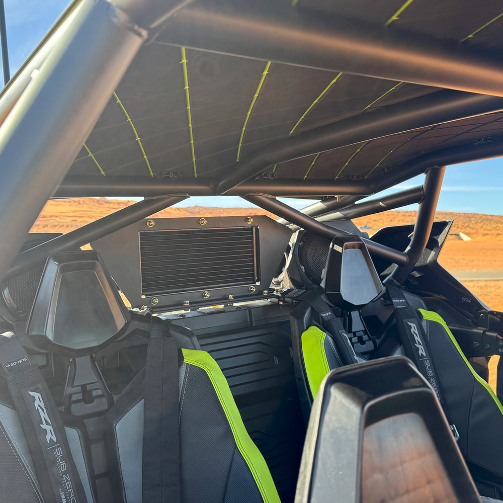 
                  
                    Interior view of a Polaris RZR Pro R showcasing the rear-mounted intercooler from the H&S Motorsports Easy Boost Turbo Kit, installed behind the seats within the roll cage.
                  
                