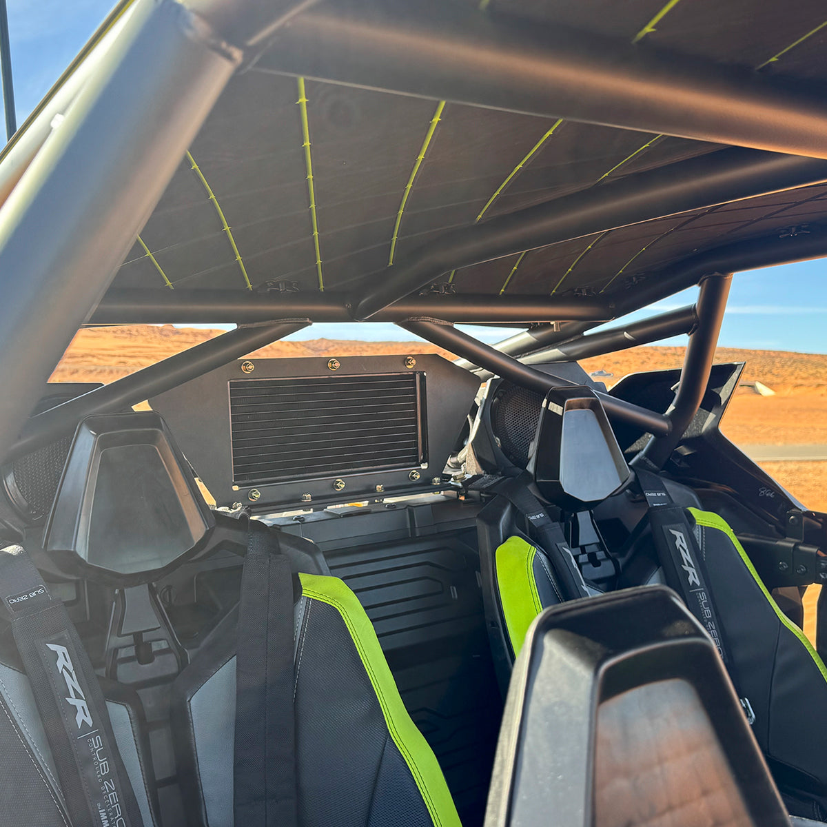 
                  
                    Interior view of a Polaris RZR Pro R showcasing the rear-mounted intercooler from the H&S Motorsports Easy Boost Turbo Kit, installed behind the seats within the roll cage.
                  
                