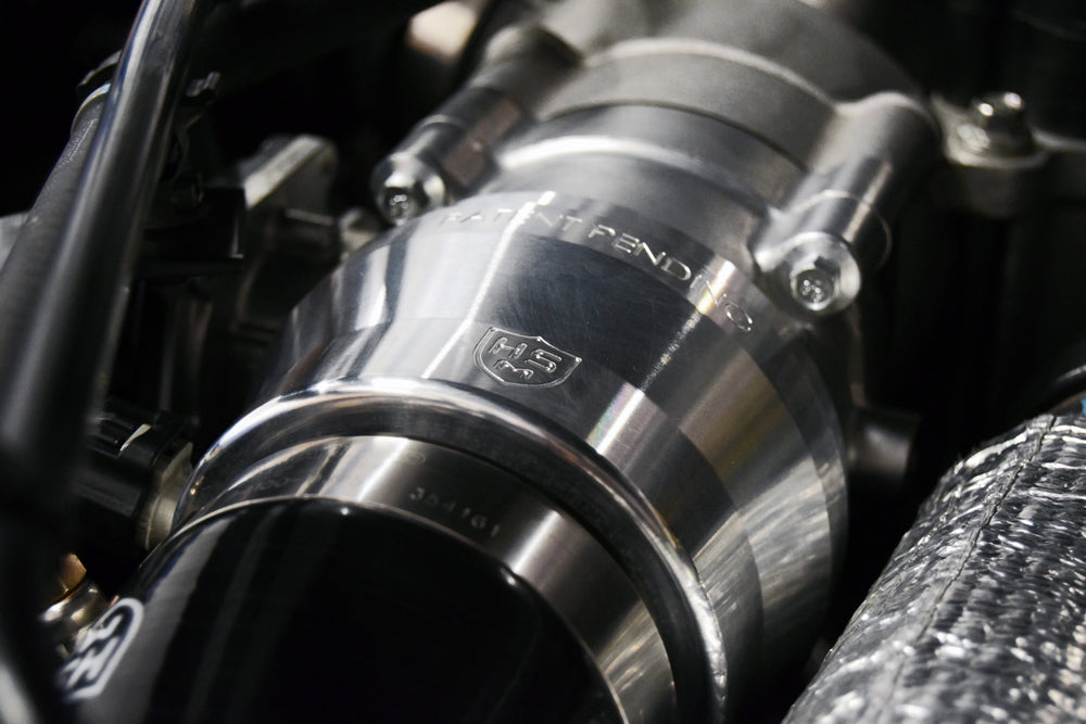 
                  
                    Close-up view of H&S Motorsports billet aluminum intercooler adapter installed on 6.7L Power Stroke engine
                  
                