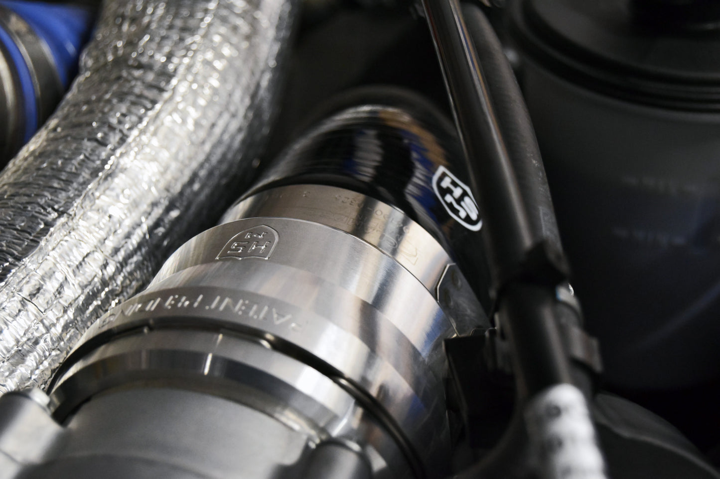 
                  
                    Detailed view of H&S Motorsports billet adapter connected to the 5-ply silicone hose installed on 6.7L Power Stroke engine.
                  
                