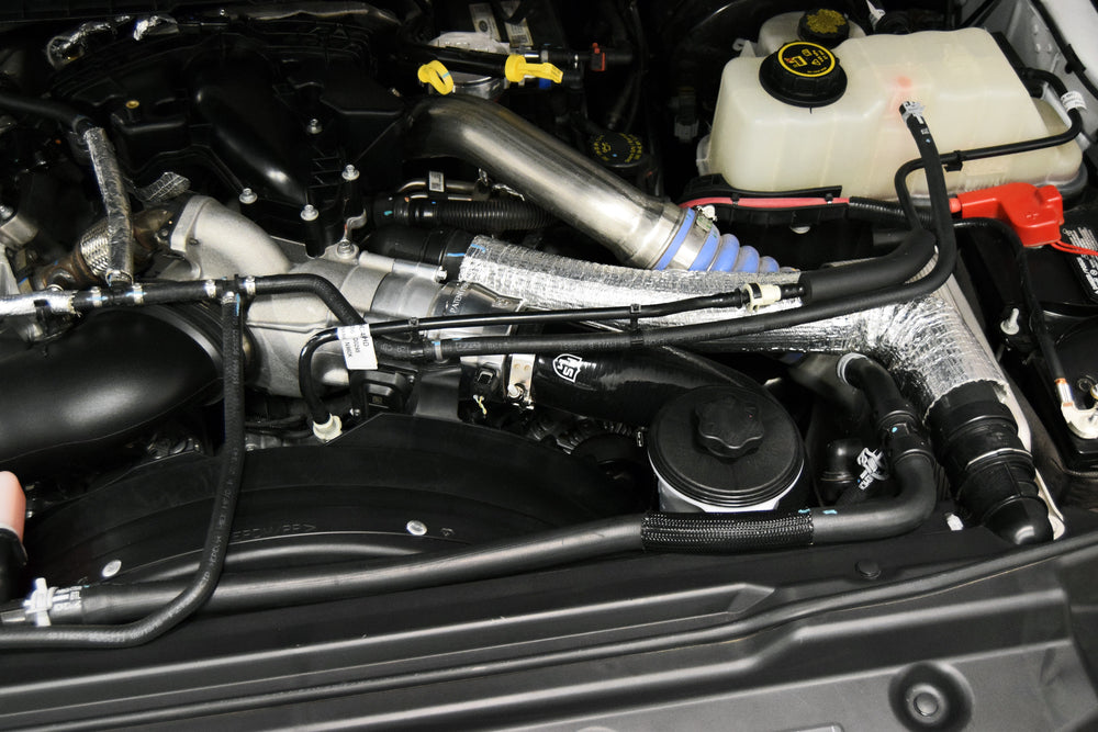 
                  
                    H&S Motorsports cold-side intercooler pipe upgrade kit installed on 6.7L Power Stroke engine, showing full engine bay layout.
                  
                